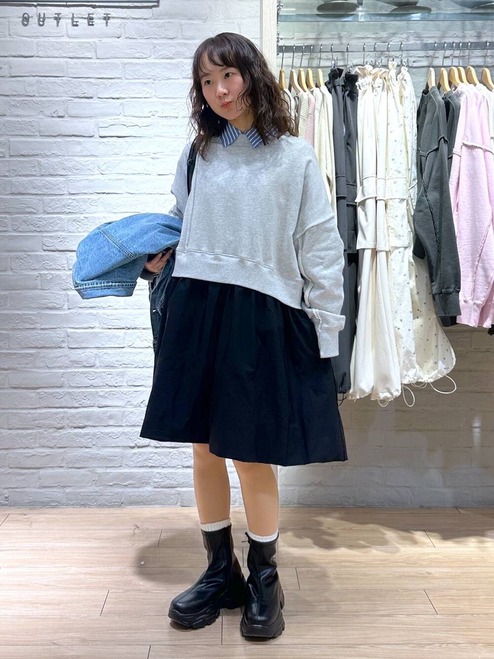 ブルー系のデニムジャケット、ブラック系のショルダーバッグ、ブラック系のブーツを着用したレディースの春コーディネートの6枚目の写真