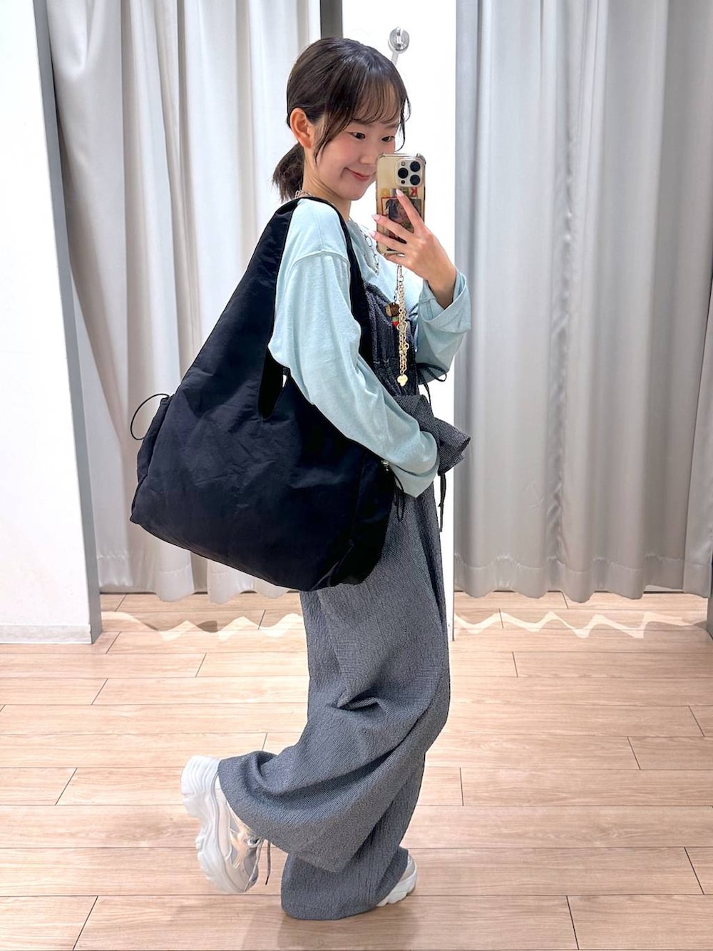 グリーン系のTシャツ/カットソー、ブラック系のトートバッグ、ブルー系のサロペット/オーバーオールを着用したレディースの春コーディネートの3枚目の写真