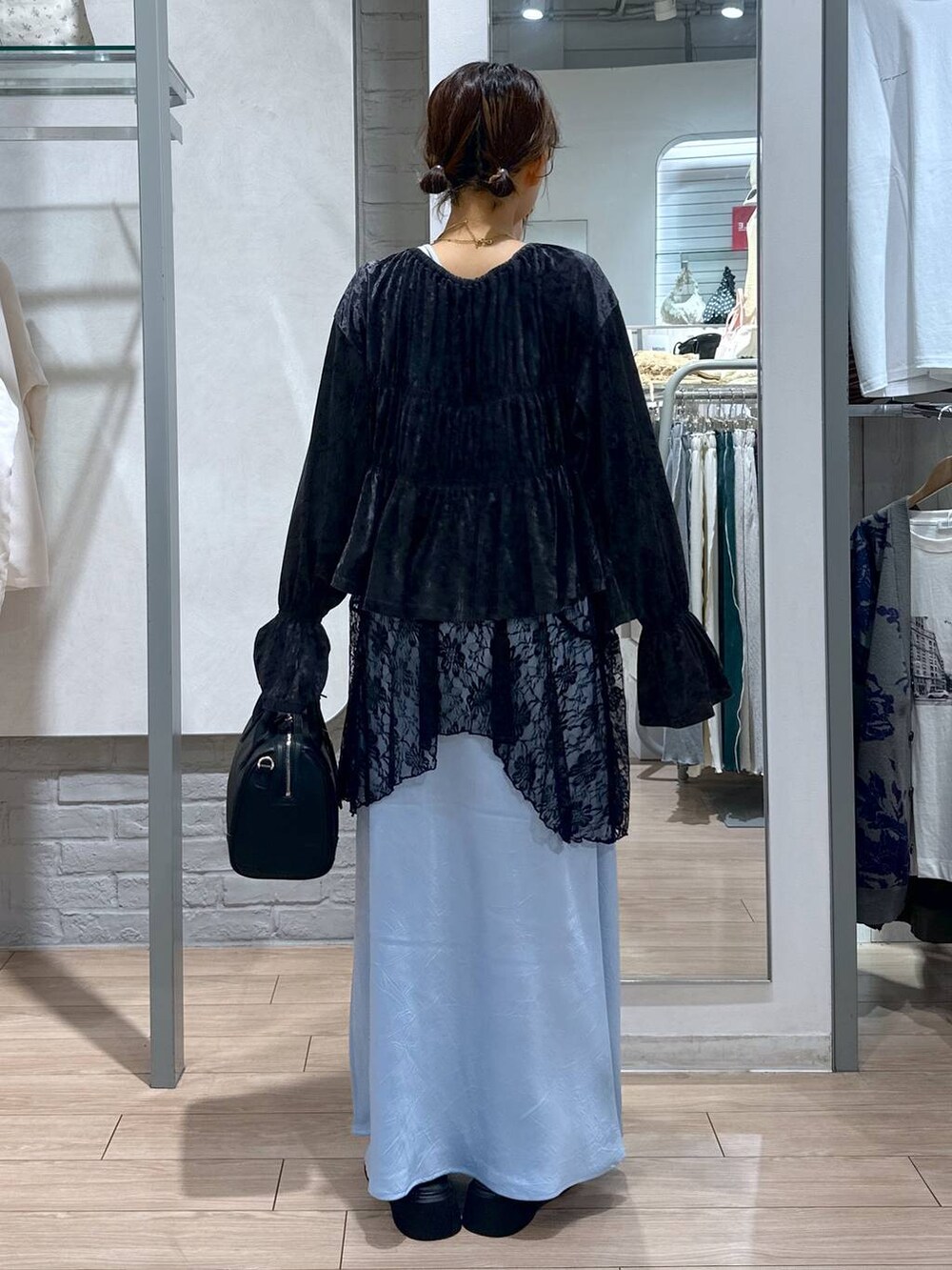 ブルー系のスカート、ブラック系のスカート、ブラック系のショルダーバッグを着用したレディースの夏コーディネートの4枚目の写真