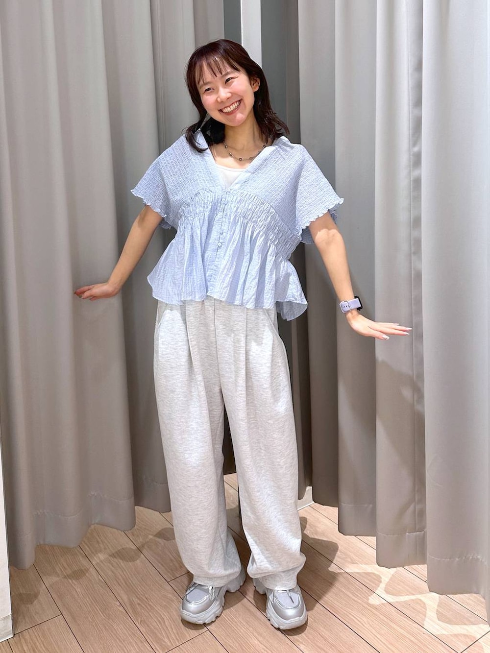 グレー系のスウェットパンツ、ホワイト系のタンクトップ、シルバー系のスニーカーを着用したレディースの春コーディネートの2枚目の写真