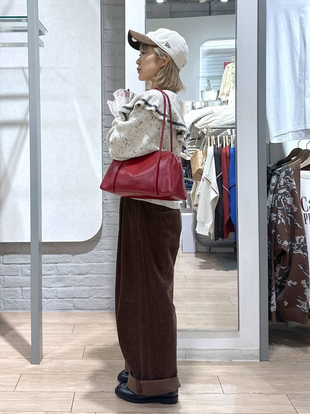 ブラウン系のその他パンツ、ホワイト系のTシャツ/カットソー、ベージュ系のニット/セーターを着用したレディースの秋コーディネートの2枚目の写真