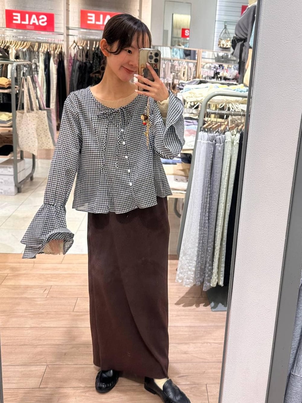 ブラウン系のスカート、ブラック系のローファー、ブラック系のシャツ/ブラウスを着用したレディースの春コーディネートの3枚目の写真