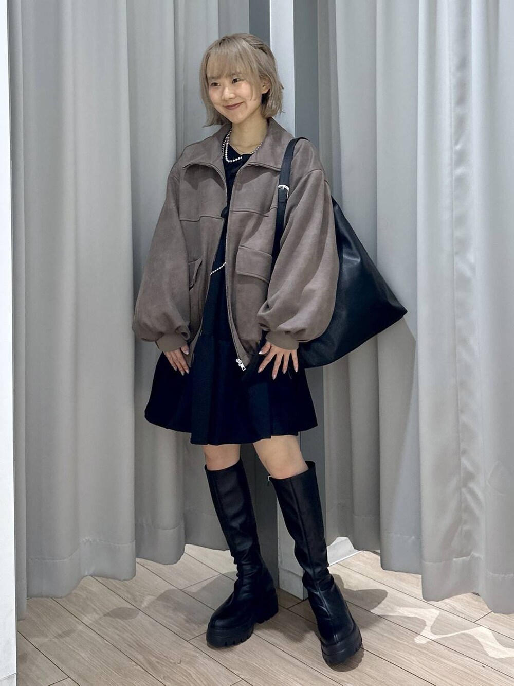 ブラック系のショルダーバッグ、ブラウン系のブルゾン、ブラック系のブーツを着用したレディースの秋コーディネートの3枚目の写真