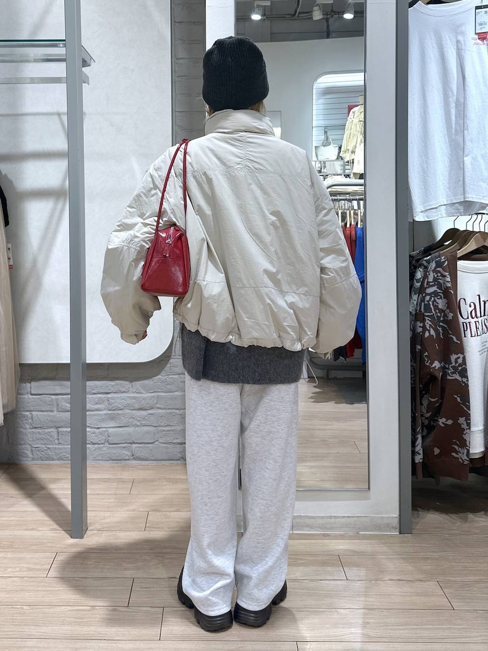 ホワイト系のその他アウター、ブラック系のブーツ、グレー系のスウェットパンツを着用したレディースの秋コーディネートの5枚目の写真