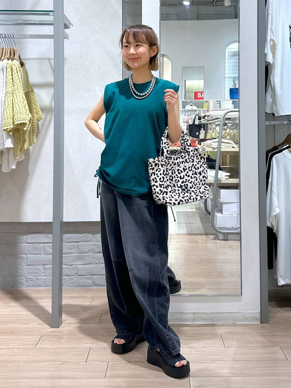 ブラック系のサンダル、ブラック系のデニムパンツ、その他のショルダーバッグを着用したレディースの夏コーディネートの2枚目の写真