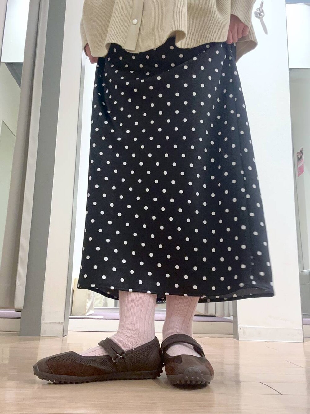 ブラック系のスカート、ブラウン系のスニーカーを着用したレディースの春コーディネートの5枚目の写真