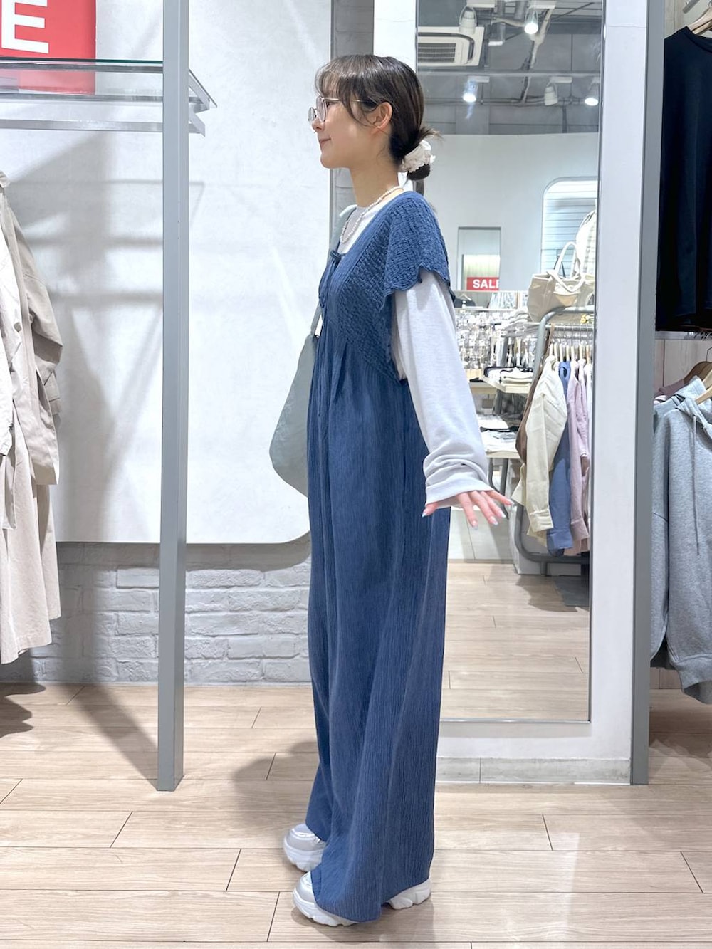 ブルー系のサロペット/オーバーオール、グレー系のTシャツ/カットソー、ブルー系のショルダーバッグを着用したレディースの春コーディネートの3枚目の写真