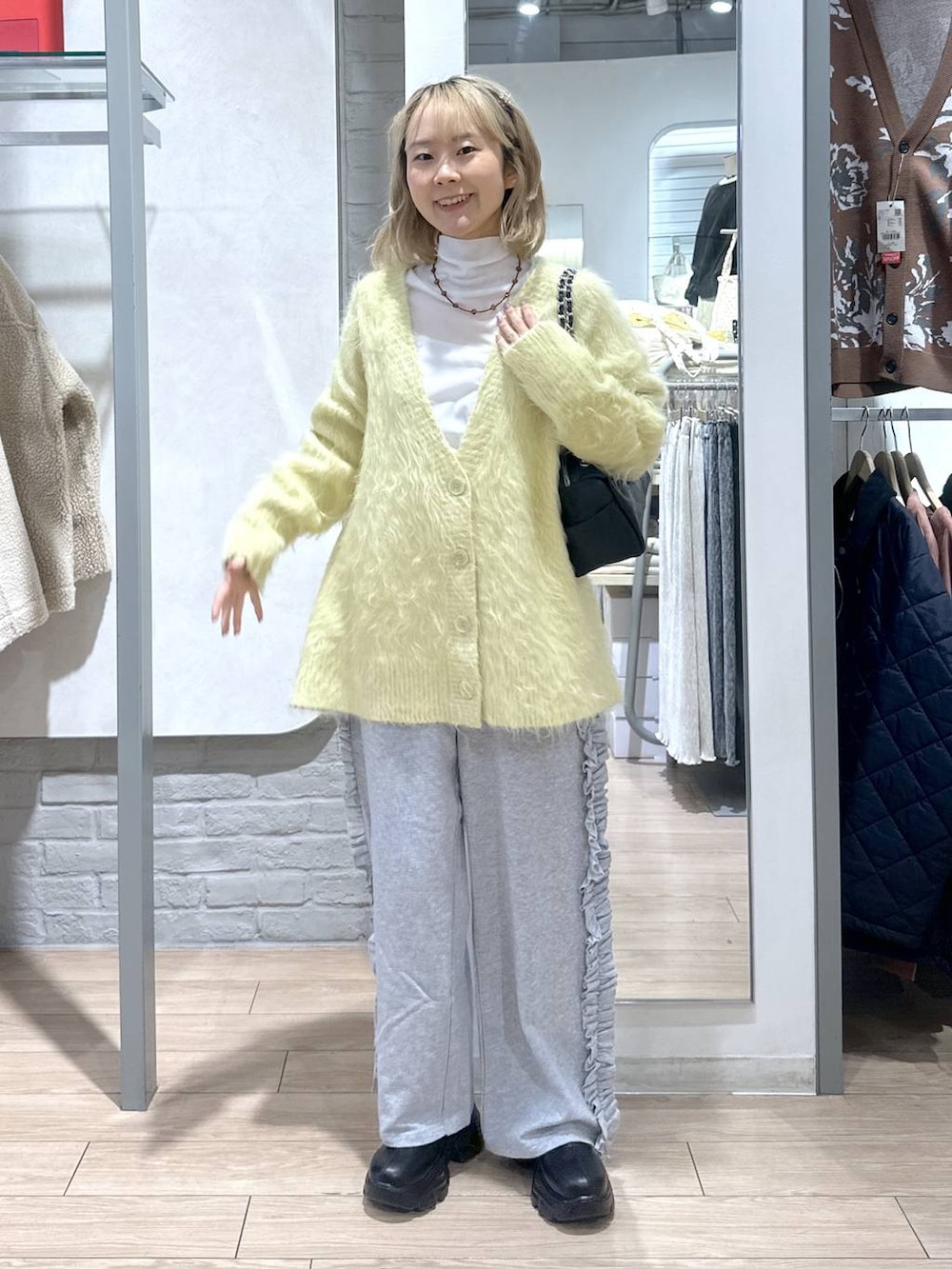 ブラック系のブーツ、イエロー系のカーディガン/ボレロ、グレー系のスウェットパンツを着用したレディースの秋コーディネートの4枚目の写真