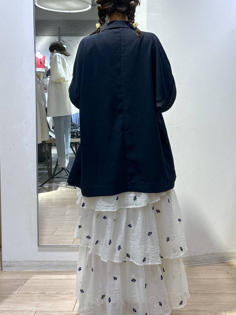 ホワイト系のTシャツ/カットソー、ブルー系のテーラードジャケット、ホワイト系のスカートを着用したレディースの夏コーディネートの4枚目の写真