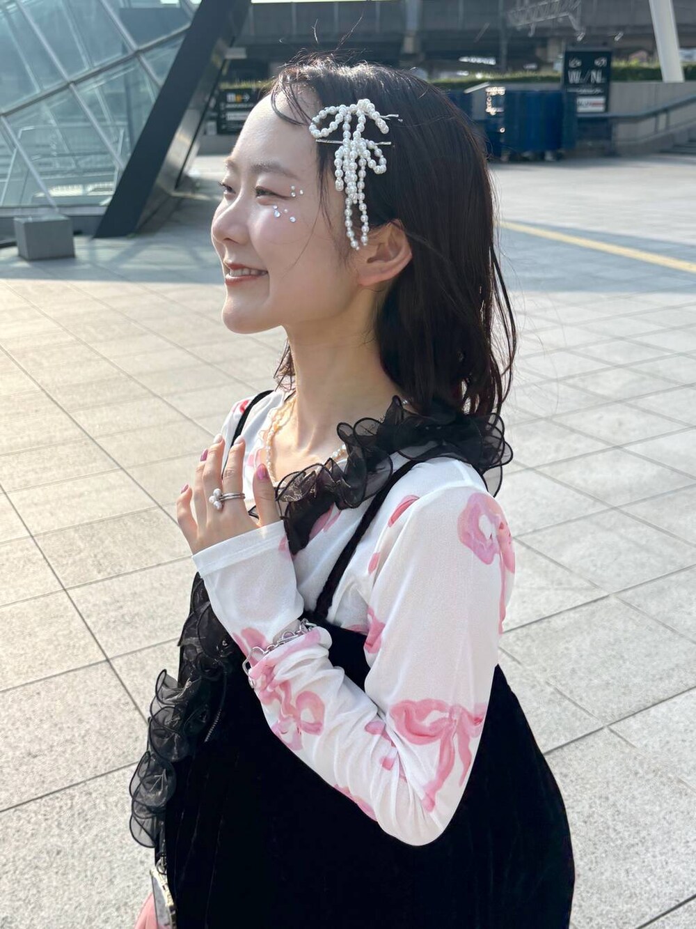 ブラック系のキャミソール、ホワイト系のバレッタ/ヘアクリップ、ブラック系のスマホグッズを着用したレディースの秋コーディネートの3枚目の写真