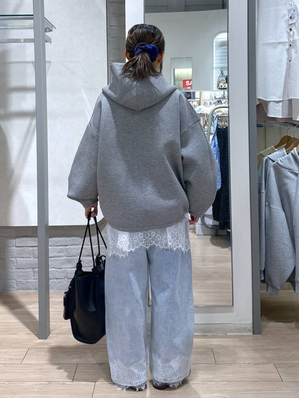 グリーン系のTシャツ/カットソー、ブルー系のデニムパンツ、ブラック系のサンダルを着用したレディースの春コーディネートの5枚目の写真