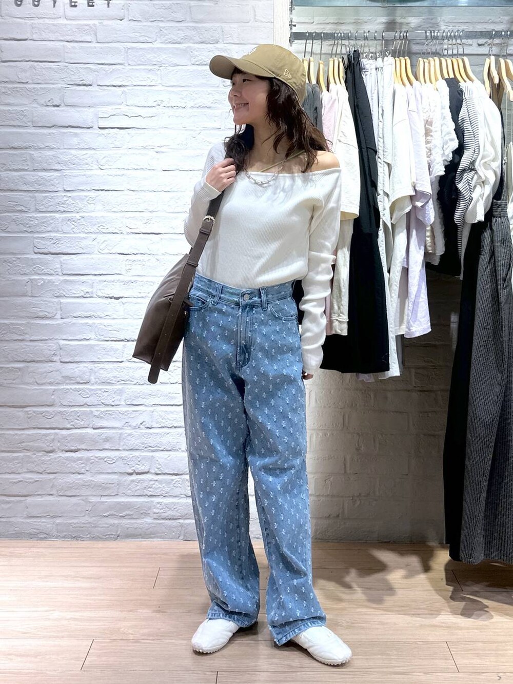 ブルー系のデニムパンツ、ホワイト系のTシャツ/カットソー、ホワイト系のスニーカーを着用したレディースの春コーディネートの2枚目の写真