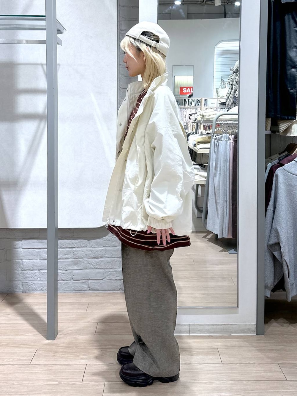 ホワイト系のナイロンジャケット、ブラウン系のデニムパンツ、ブラウン系のローファーを着用したレディースの冬コーディネートの3枚目の写真