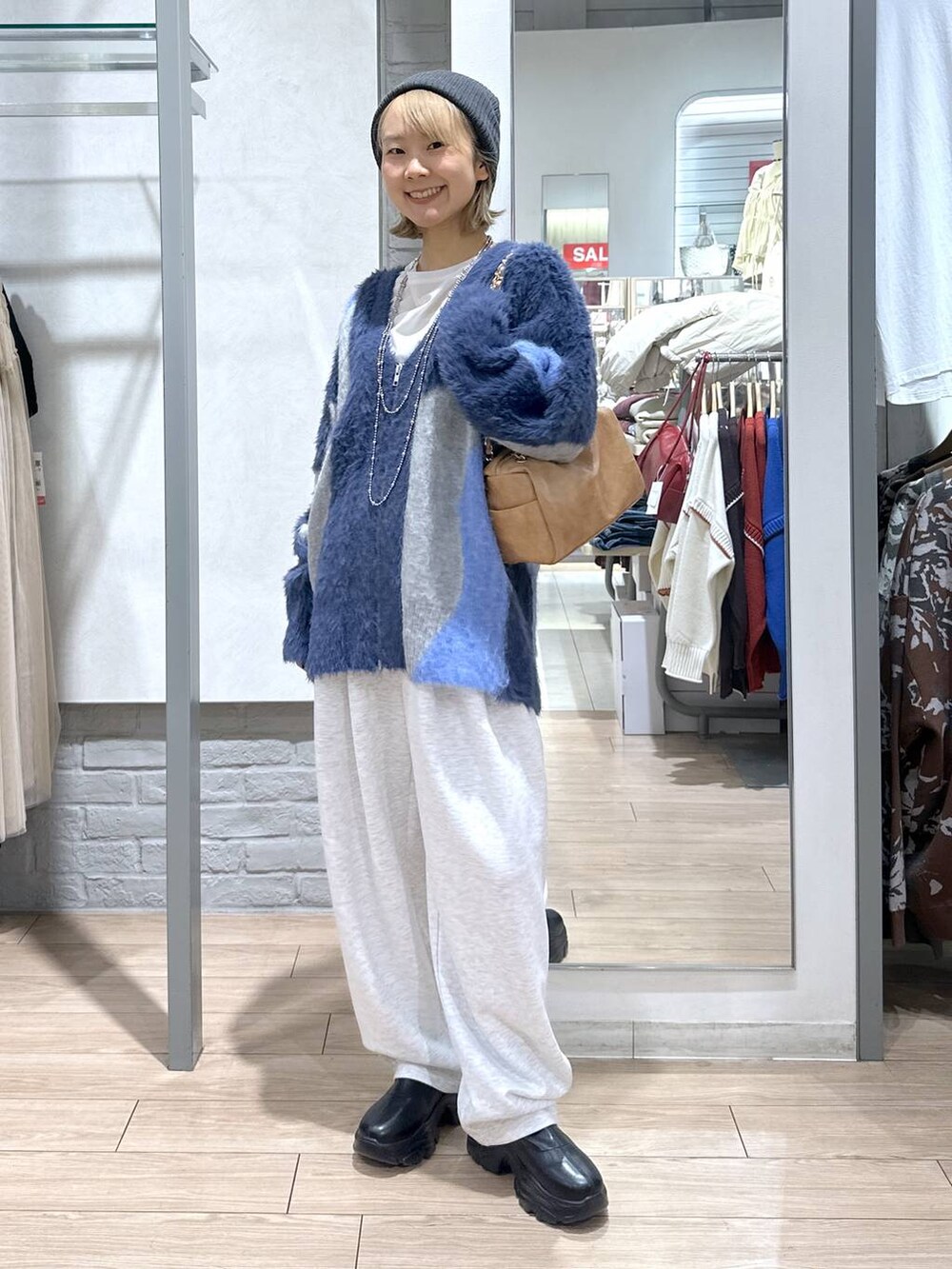 ブラック系のブーツ、ブルー系のカーディガン/ボレロ、グレー系のスウェットパンツを着用したレディースの秋コーディネートの4枚目の写真
