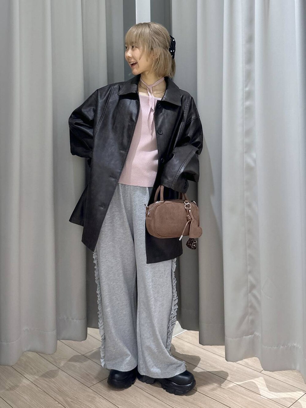 ブラック系のブーツ、ブラウン系のカバーオール、ピンク系のニット/セーターを着用したレディースの秋コーディネートの2枚目の写真