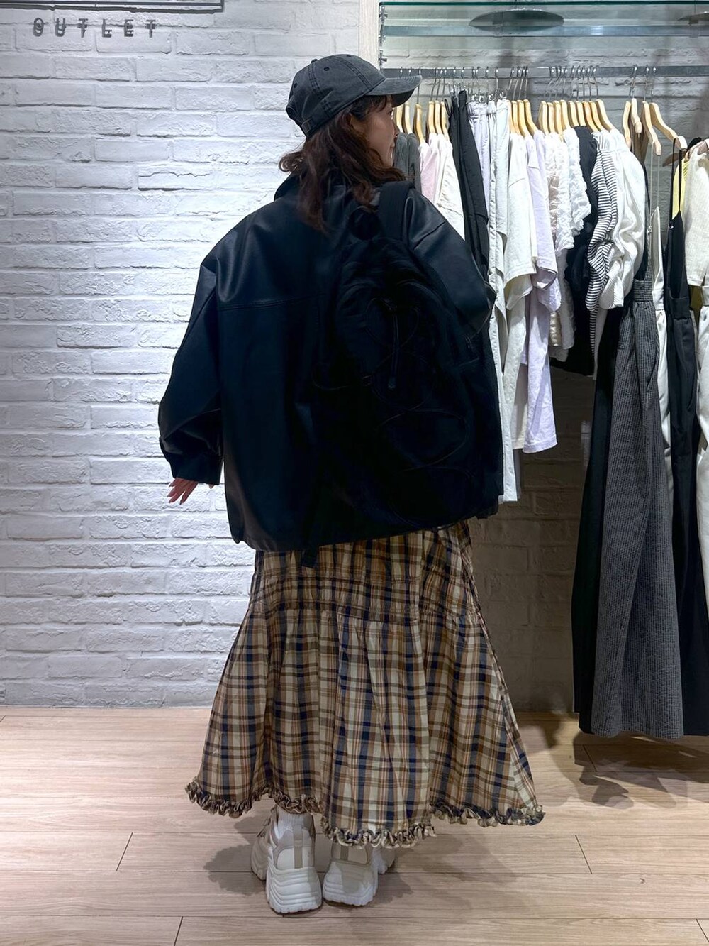 ブラック系のブルゾン、ブラック系のバックパック/リュック、ベージュ系のスニーカーを着用したレディースの春コーディネートの6枚目の写真