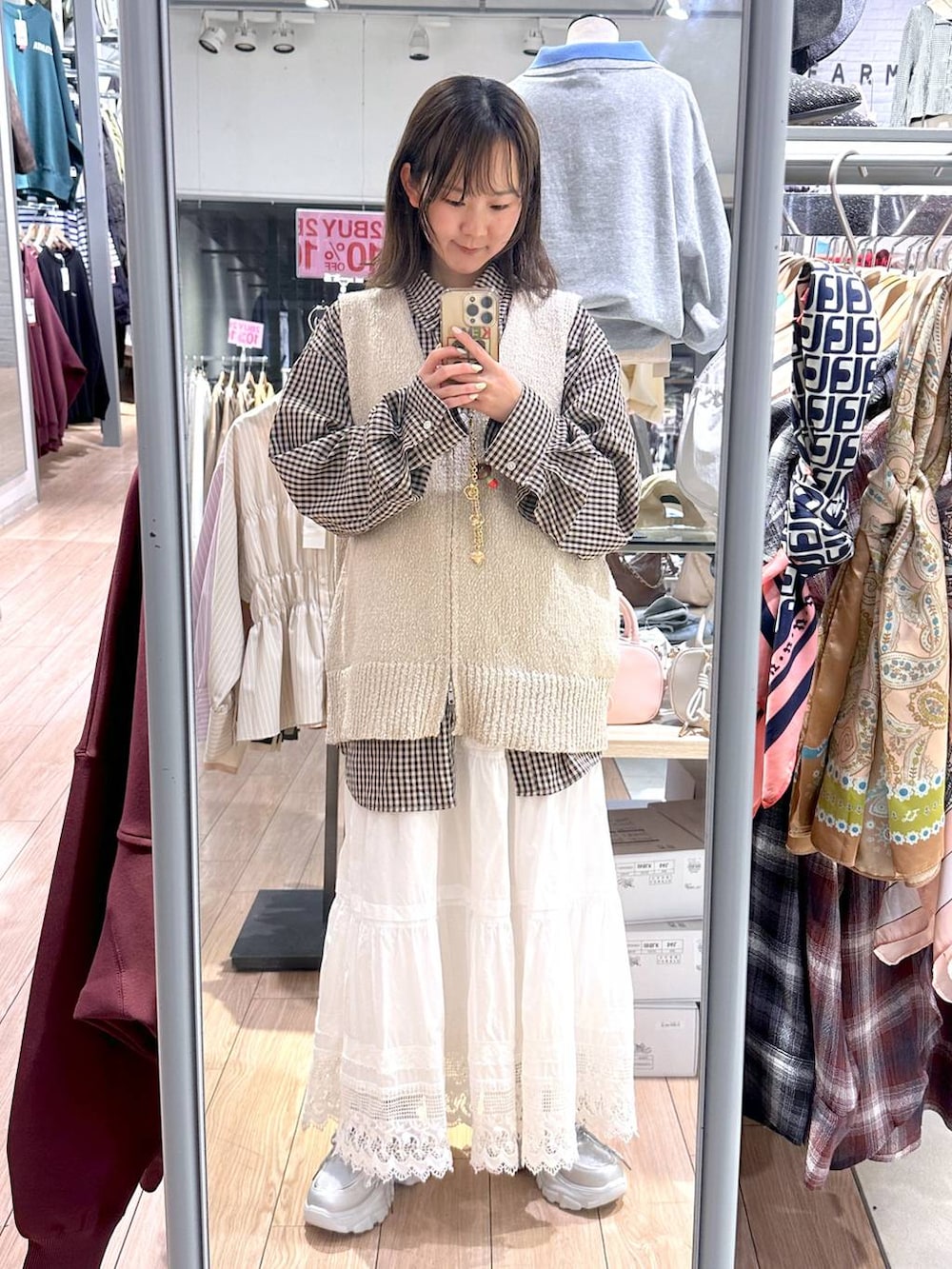 ブラウン系のシャツ/ブラウス、ベージュ系のベスト、ホワイト系のスカートを着用したレディースの春コーディネートの3枚目の写真