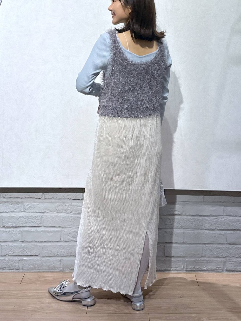 シルバー系のパンプス、グレー系のキャミソール、シルバー系のショルダーバッグを着用したレディースの秋コーディネートの3枚目の写真