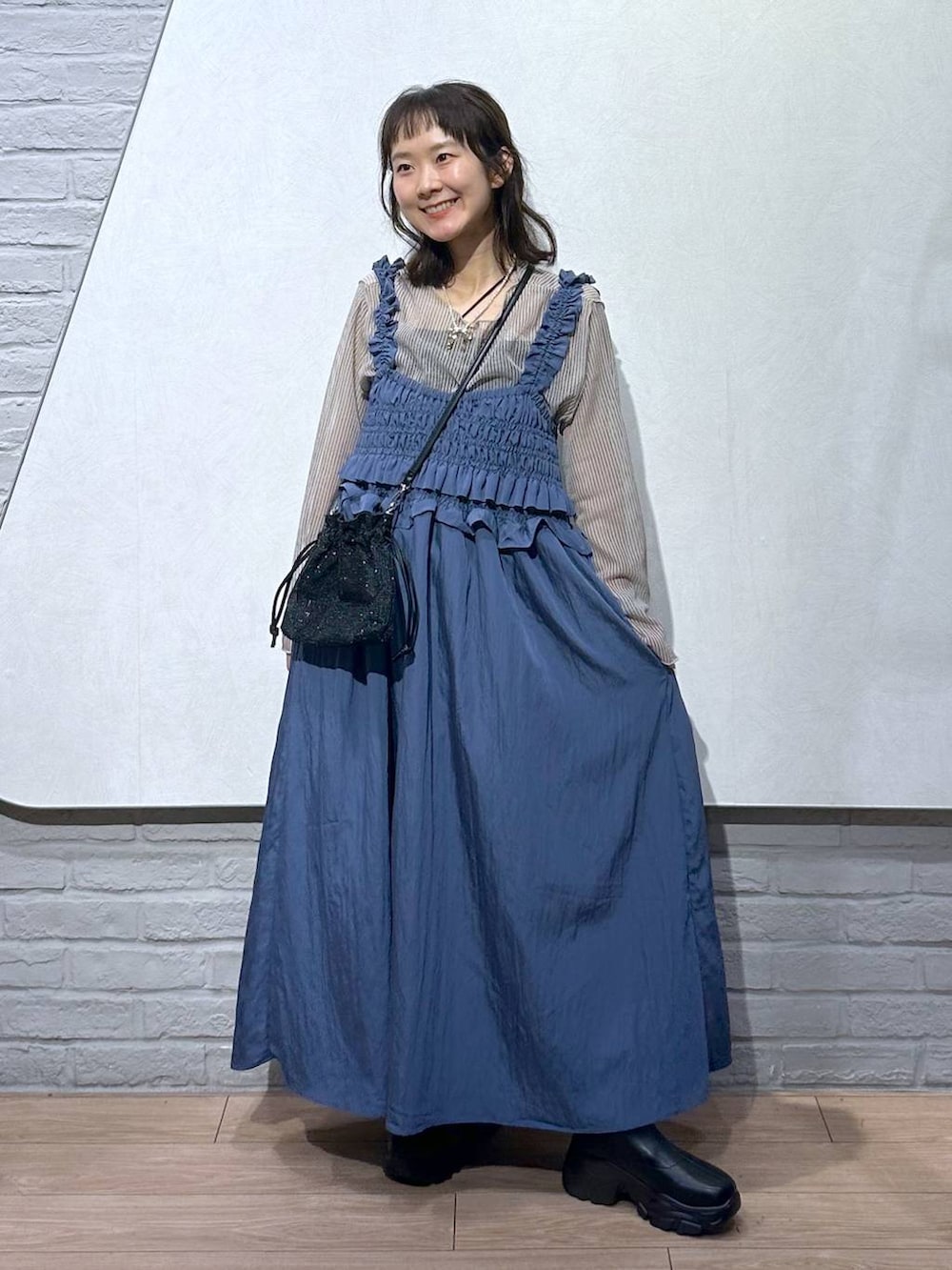 ブラック系のブーツ、ホワイト系のシャツ/ブラウス、ブラック系のキャミソールを着用したレディースの秋コーディネートの4枚目の写真