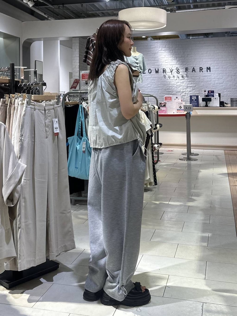 ホワイト系のTシャツ/カットソー、グレー系のスウェットパンツ、ブラック系のサンダルを着用したレディースの夏コーディネートの2枚目の写真