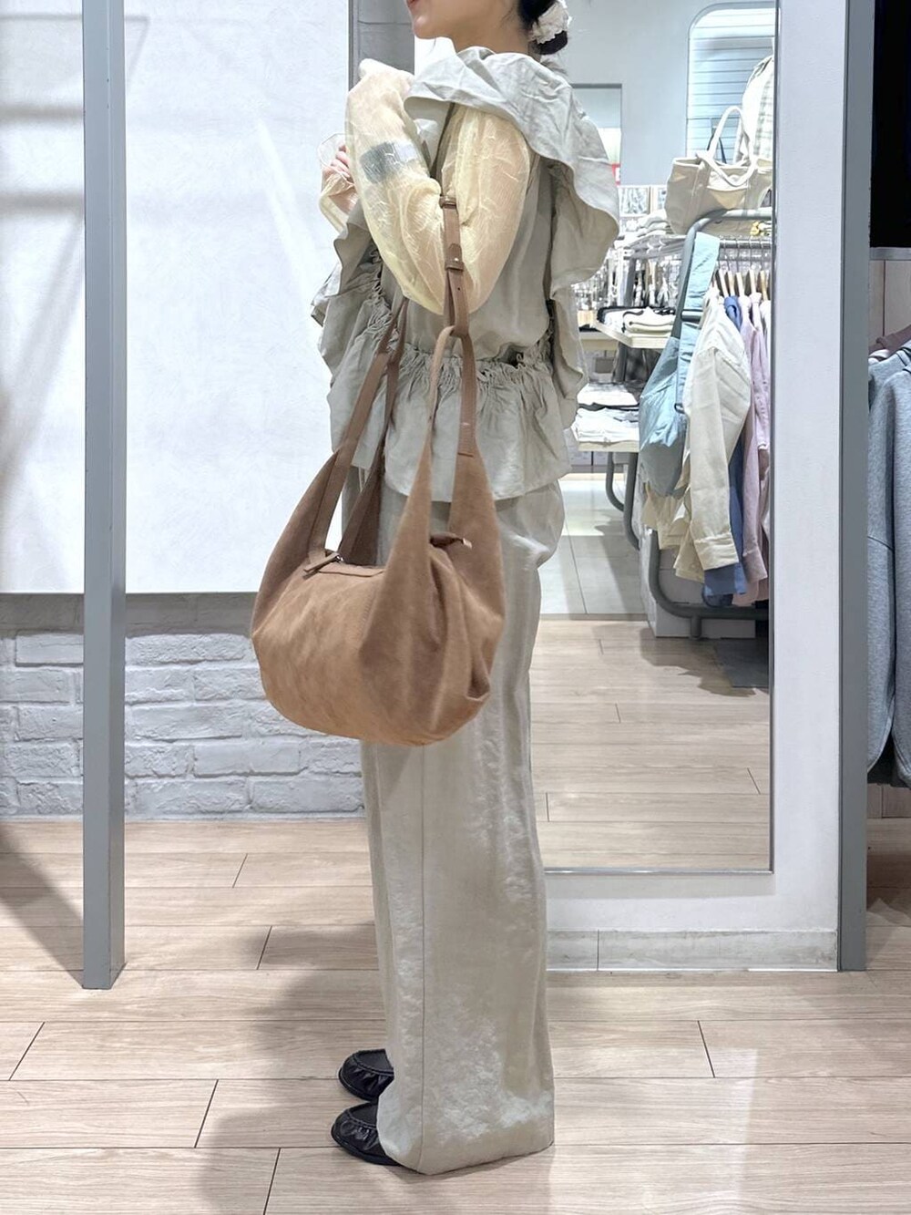 ゴールド系のタンクトップ、ブラック系のローファー、ブラウン系のショルダーバッグを着用したレディースの春コーディネートの4枚目の写真