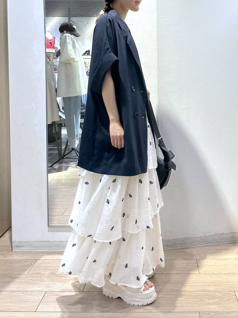 ホワイト系のTシャツ/カットソー、ブルー系のテーラードジャケット、ホワイト系のスカートを着用したレディースの夏コーディネートの3枚目の写真