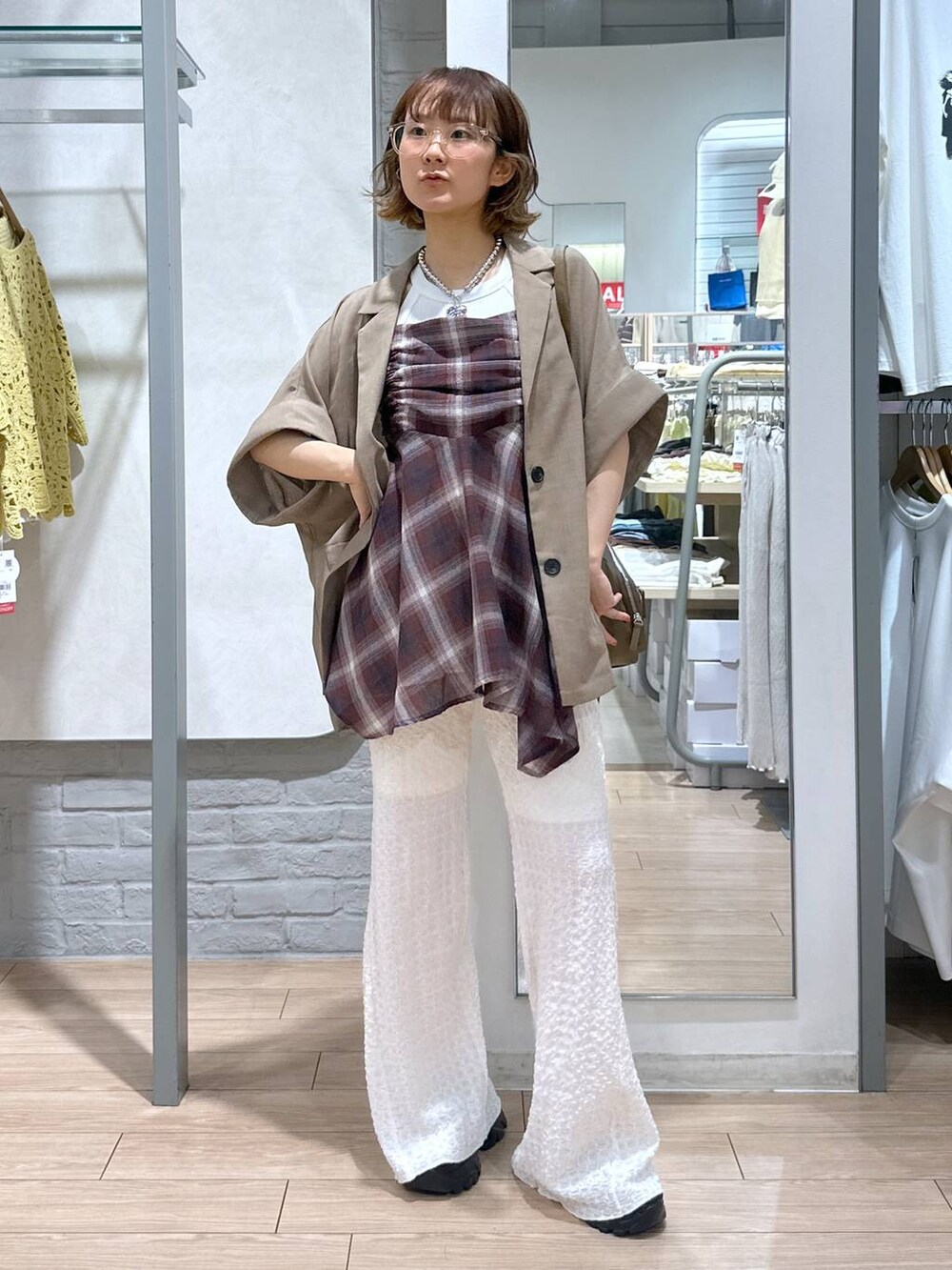 ブラック系のサンダル、ホワイト系のその他パンツ、ベージュ系のテーラードジャケットを着用したレディースの夏コーディネートの5枚目の写真