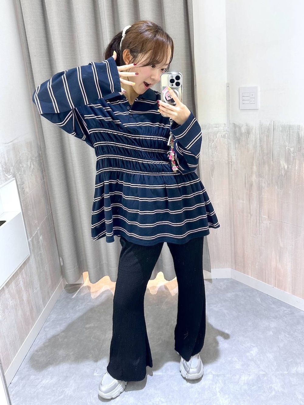ブルー系のポロシャツ、ブラック系のその他パンツ、シルバー系のスニーカーを着用したレディースの秋コーディネートの4枚目の写真