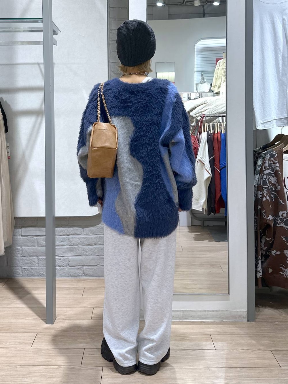 ブラック系のブーツ、ブルー系のカーディガン/ボレロ、グレー系のスウェットパンツを着用したレディースの秋コーディネートの5枚目の写真