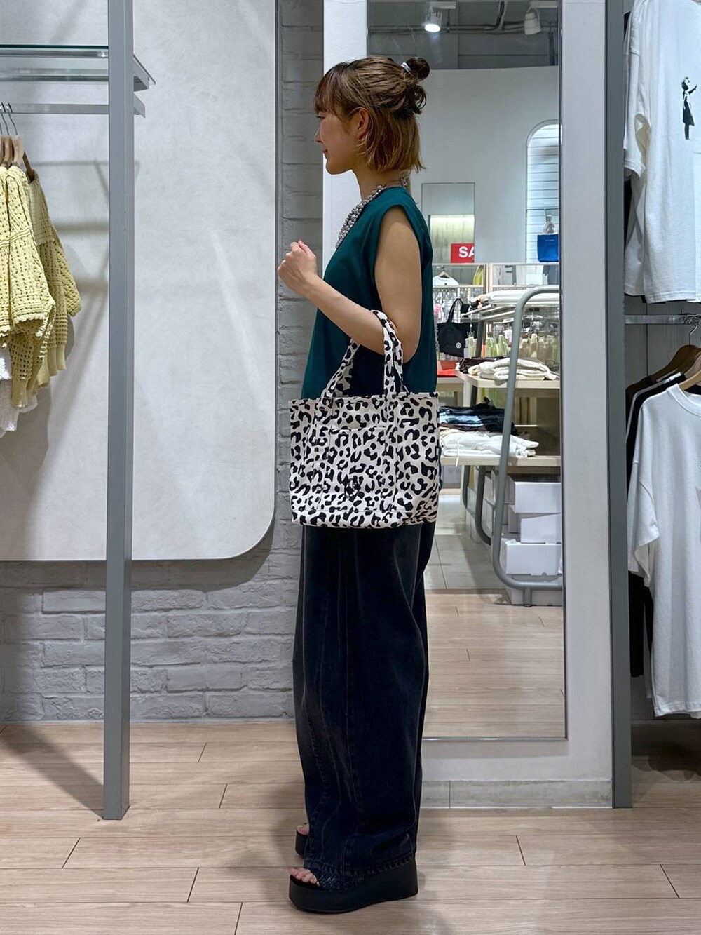 ブラック系のサンダル、ブラック系のデニムパンツ、その他のショルダーバッグを着用したレディースの夏コーディネートの3枚目の写真