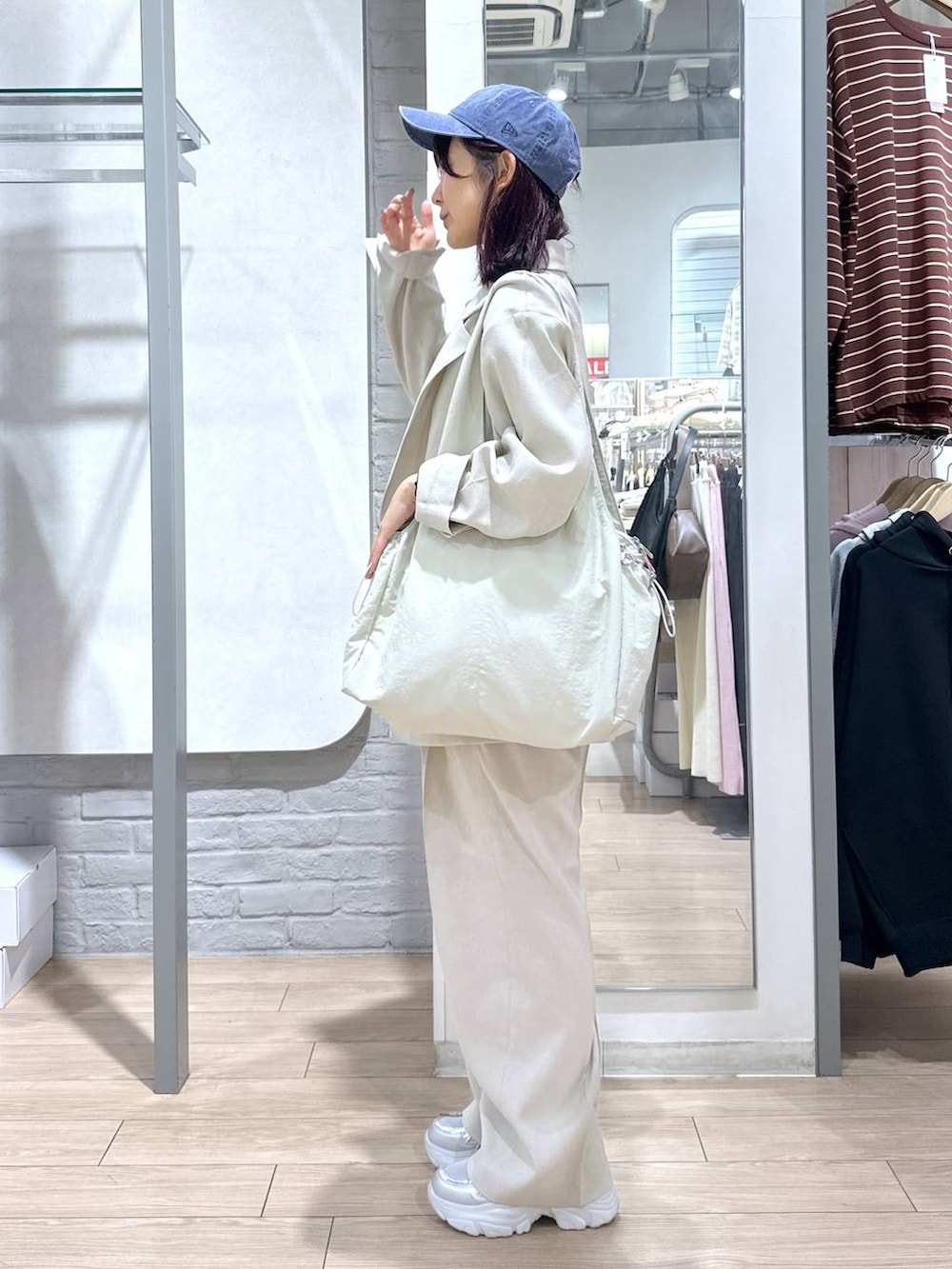 ベージュ系のその他アウター、ベージュ系のその他パンツ、ホワイト系のトートバッグを着用したレディースの春コーディネートの2枚目の写真