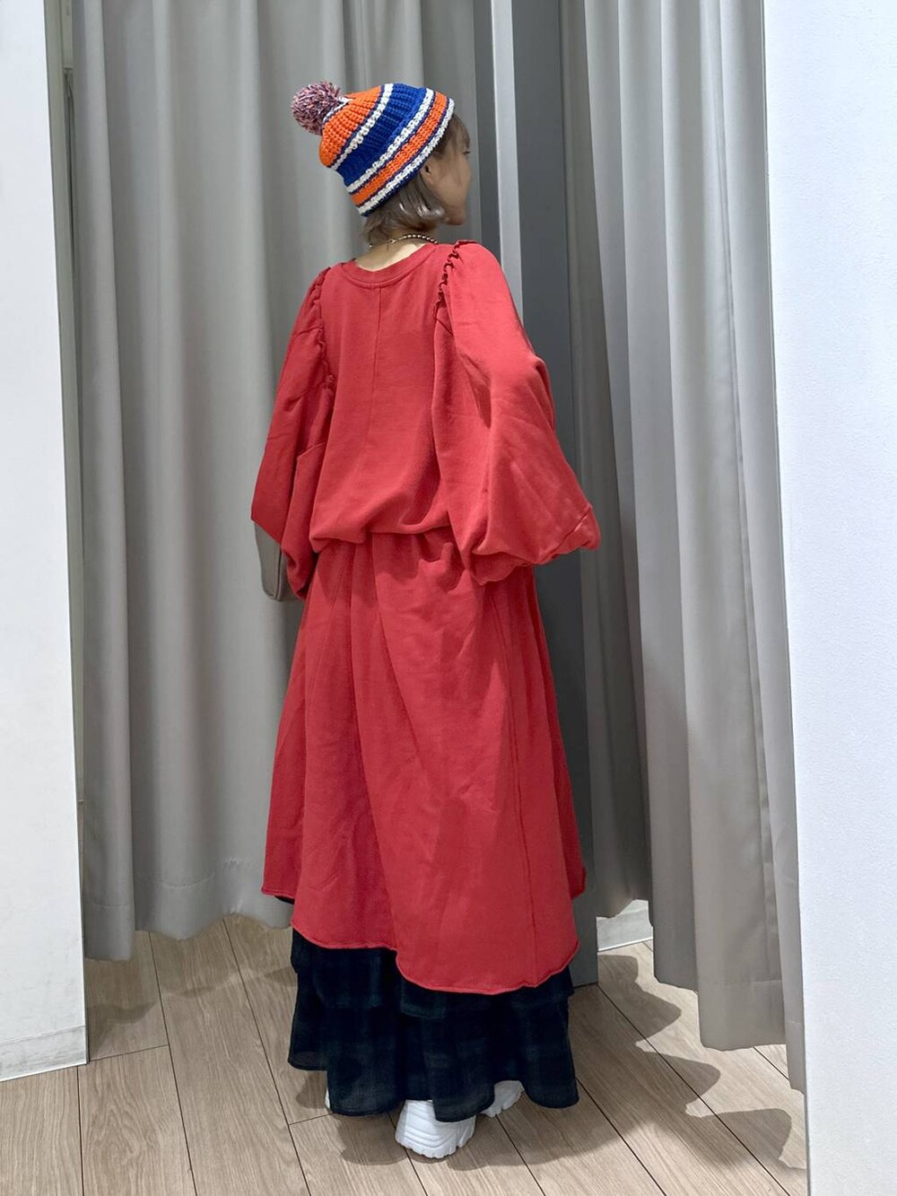 グレー系のショルダーバッグ、グリーン系のスカート、シルバー系のスニーカーを着用したレディースの秋コーディネートの4枚目の写真