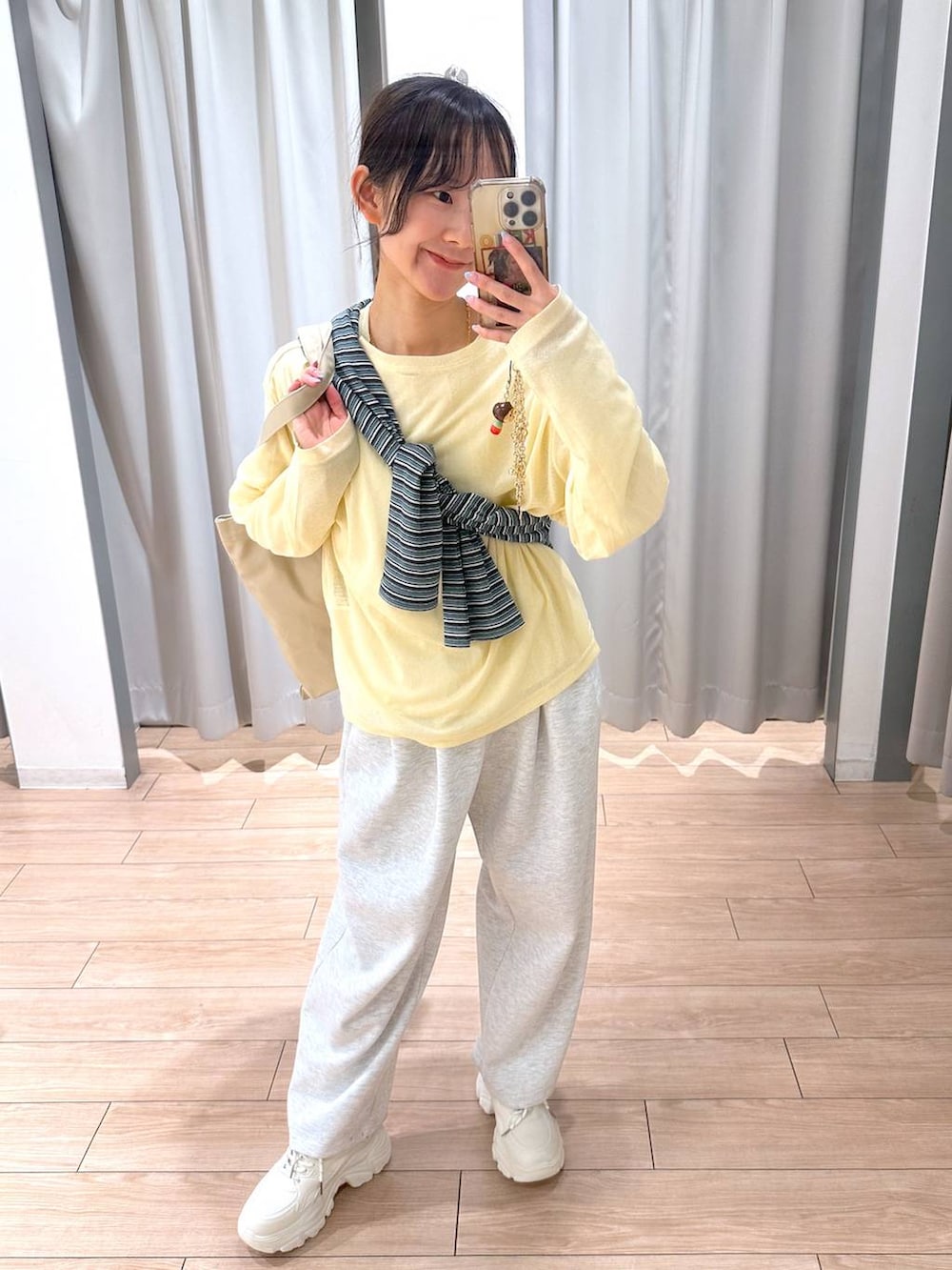 グレー系のスウェットパンツ、イエロー系のTシャツ/カットソー、ベージュ系のトートバッグを着用したレディースの春コーディネートの2枚目の写真