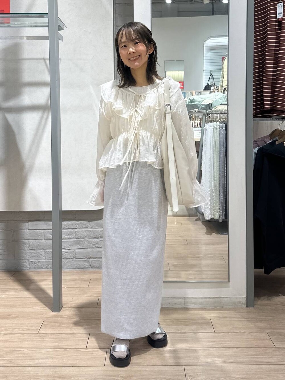 ベージュ系のTシャツ/カットソー、グレー系のスカート、ホワイト系のショルダーバッグを着用したレディースの春コーディネートの4枚目の写真