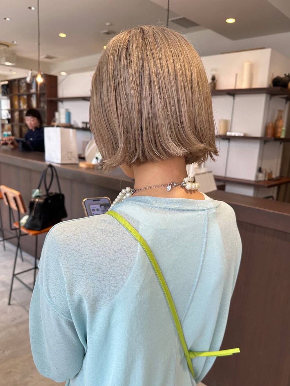 グリーン系のTシャツ/カットソー、ベージュ系のネックレスを着用したレディースの夏コーディネートの4枚目の写真