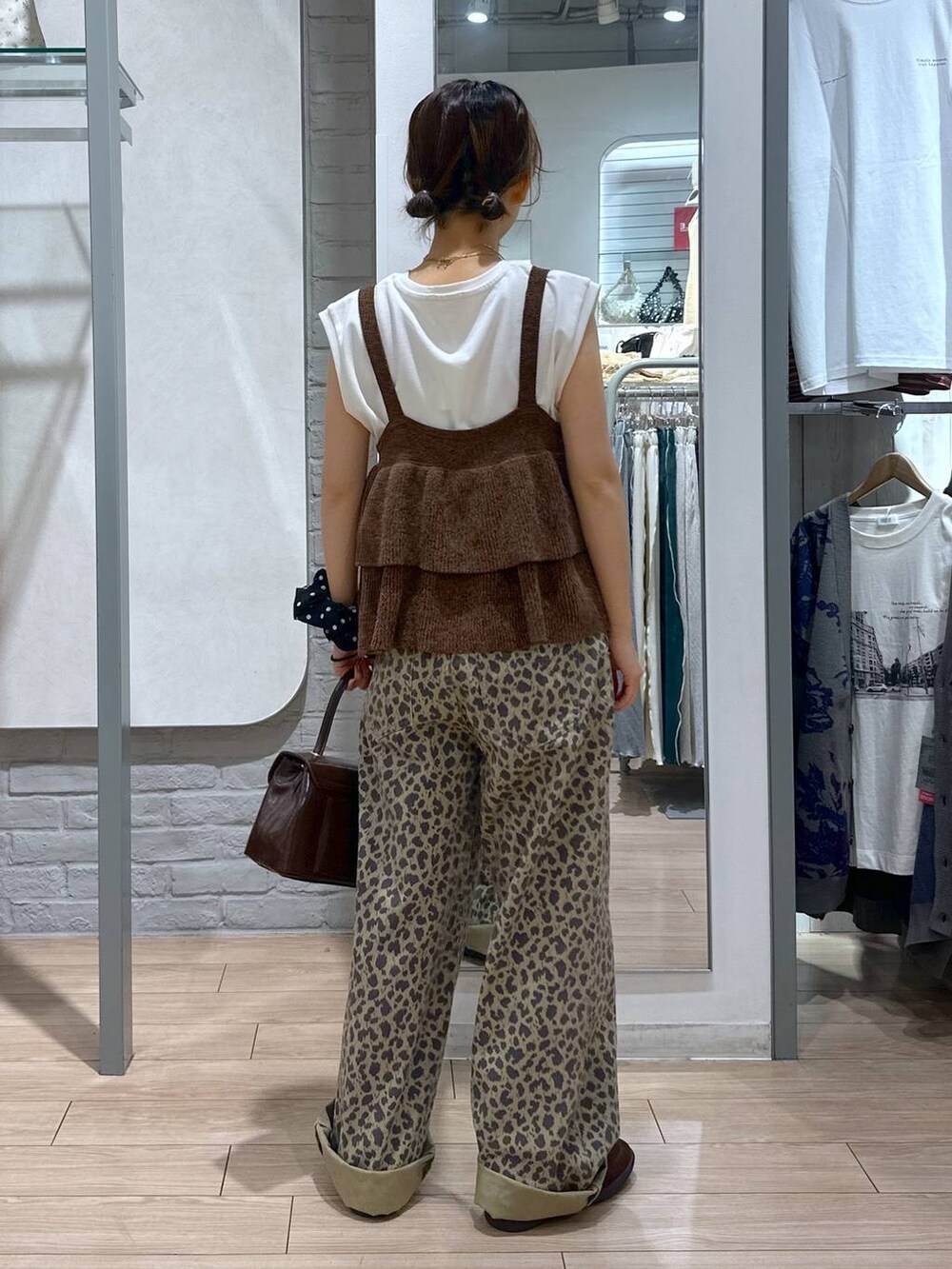 ブラウン系のスニーカー、その他のデニムパンツ、ブラウン系のボストンバッグを着用したレディースの秋コーディネートの5枚目の写真