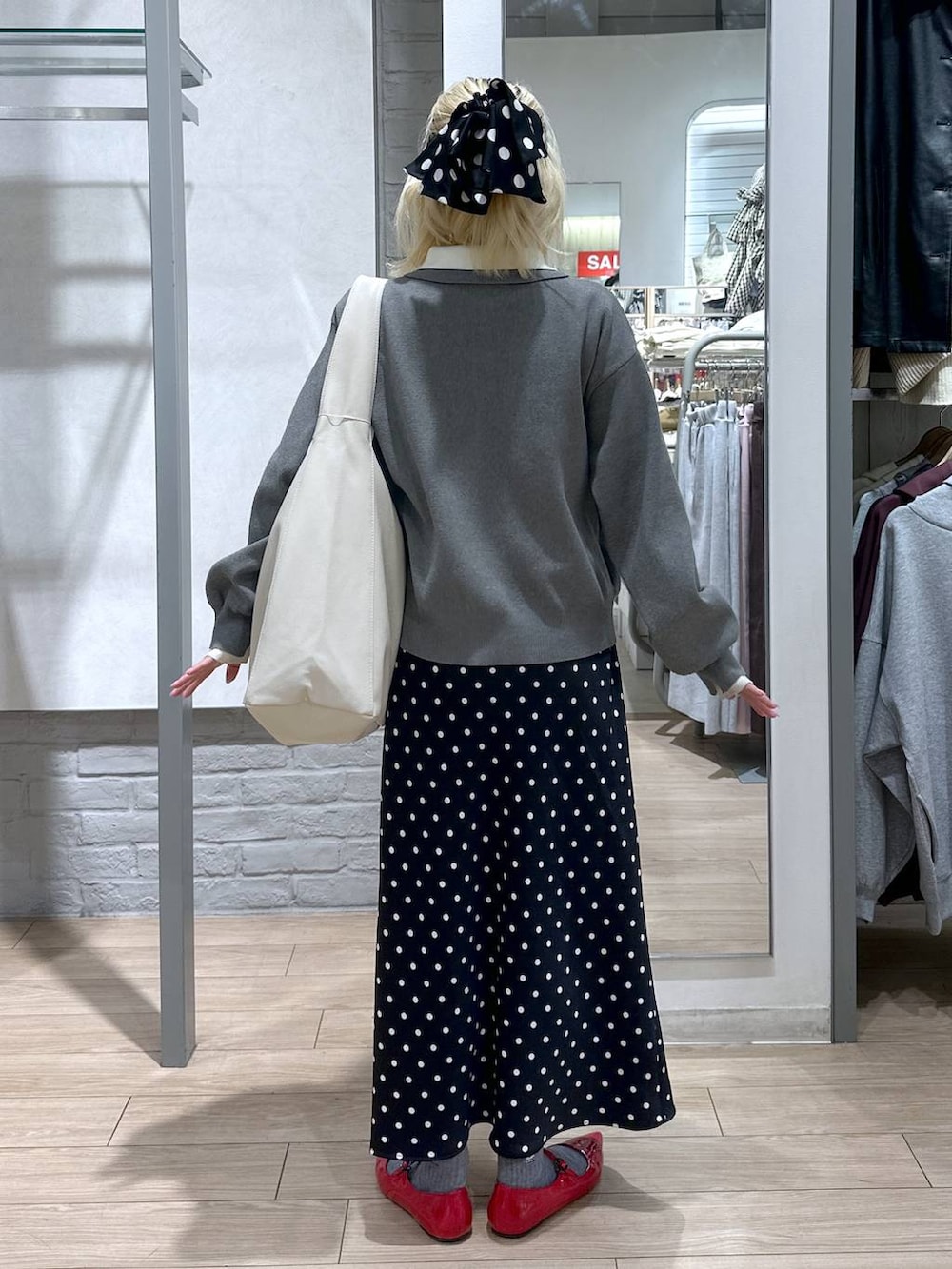 ブラック系のスカート、レッド系のパンプス、ホワイト系のショルダーバッグを着用したレディースの冬コーディネートの5枚目の写真