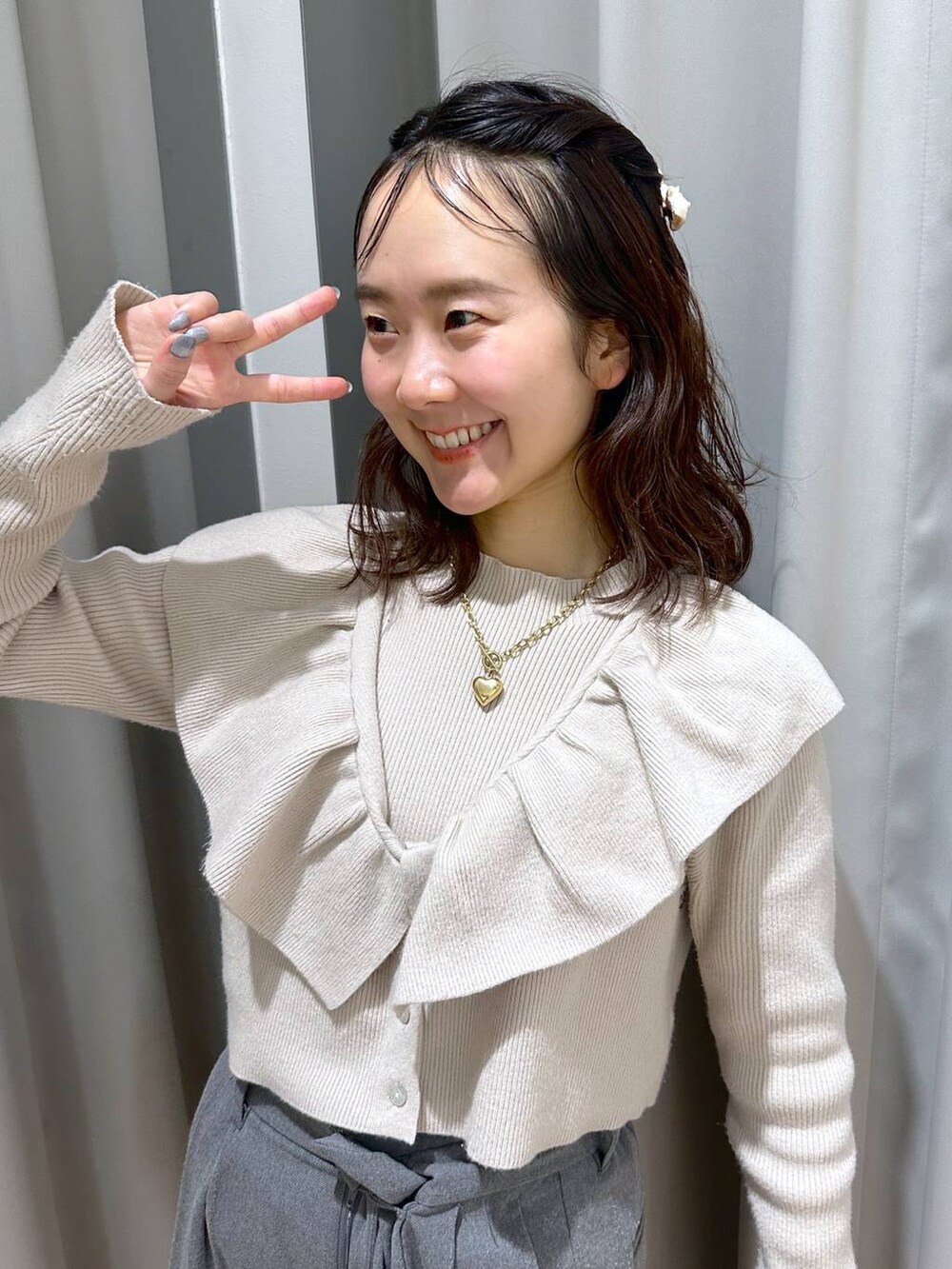ベージュ系のニット/セーター、ブラウン系のネックレス、ホワイト系のバレッタ/ヘアクリップを着用したレディースの冬コーディネートの7枚目の写真