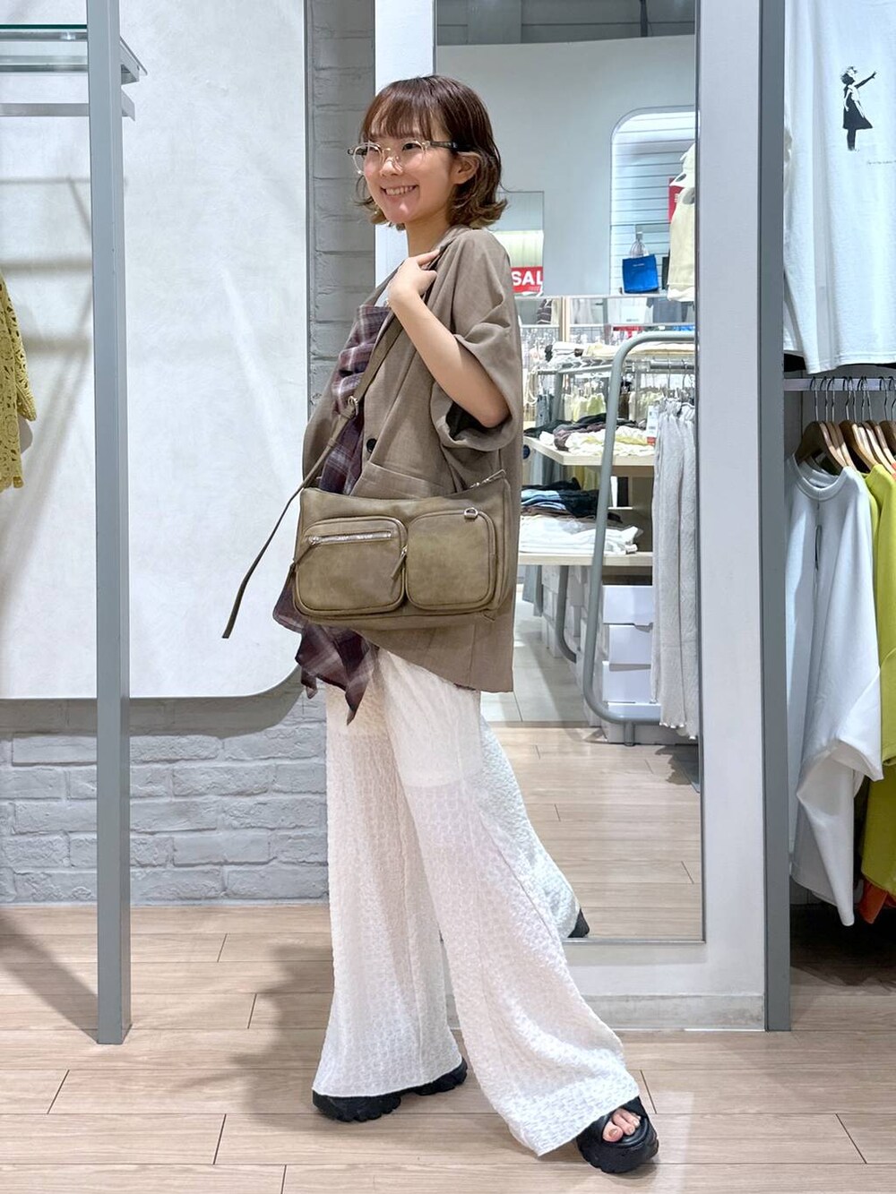 ブラック系のサンダル、ホワイト系のその他パンツ、ベージュ系のテーラードジャケットを着用したレディースの夏コーディネートの2枚目の写真