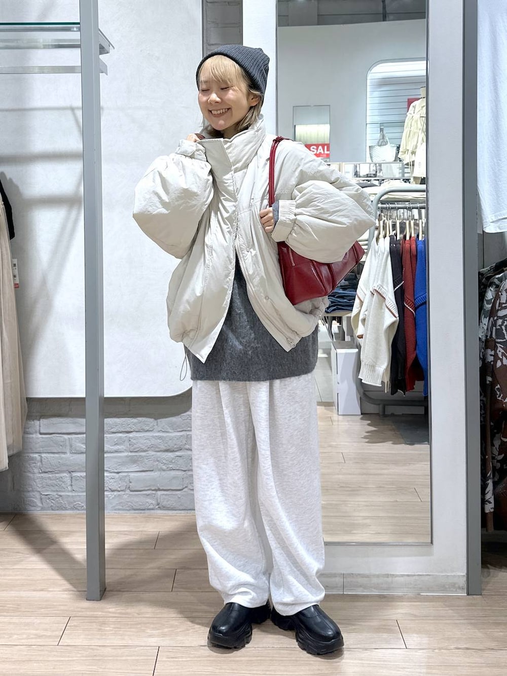 ホワイト系のその他アウター、ブラック系のブーツ、グレー系のスウェットパンツを着用したレディースの秋コーディネートの2枚目の写真