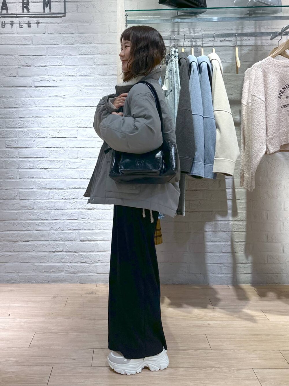 ブラック系のスカート、グリーン系のブルゾン、ベージュ系のスニーカーを着用したレディースの冬コーディネートの4枚目の写真