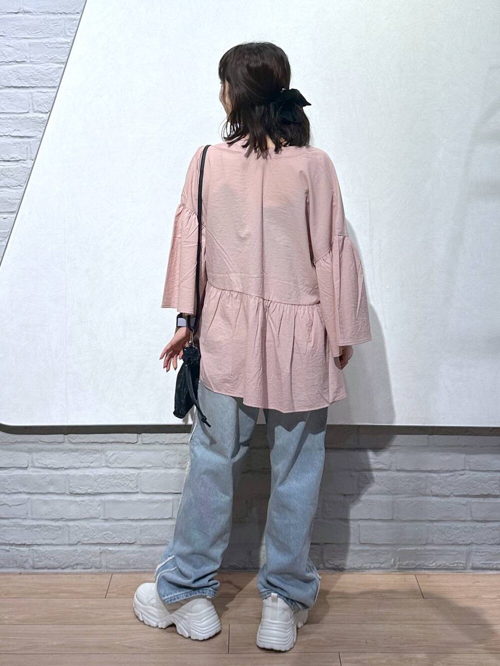 ピンク系のシャツ/ブラウス、ホワイト系のスニーカー、ブラック系のキャミソールを着用したレディースの秋コーディネートの4枚目の写真