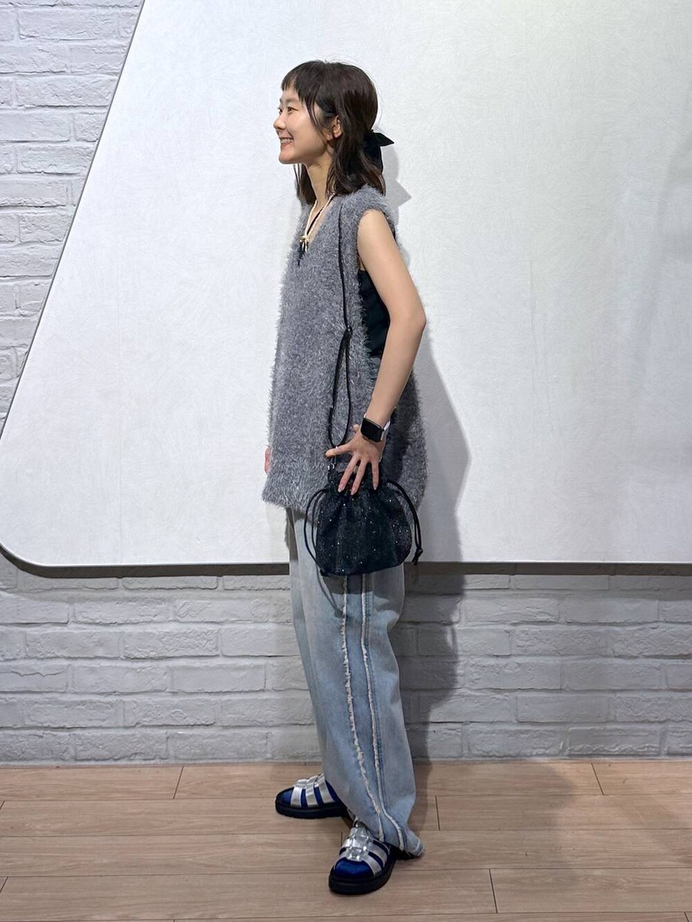 ブルー系のデニムパンツ、シルバー系のスニーカー、ブラック系のキャミソールを着用したレディースの夏コーディネートの3枚目の写真