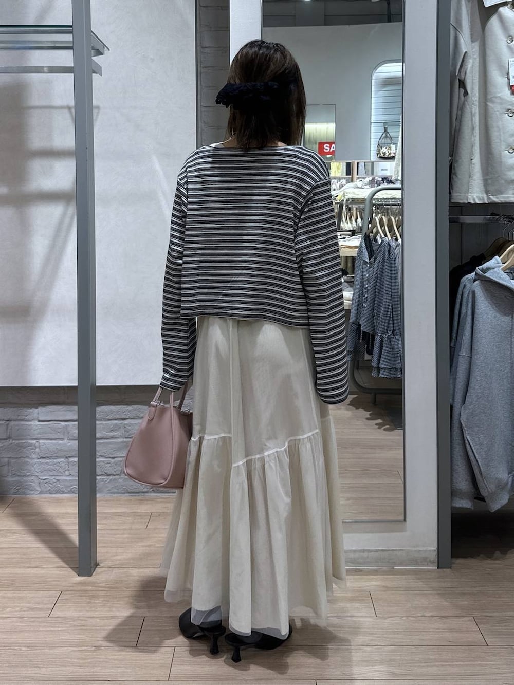 ピンク系のショルダーバッグ、ブラック系のサンダル、ホワイト系のニット/セーターを着用したレディースの春コーディネートの5枚目の写真