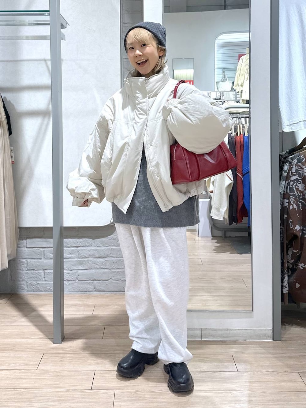 ホワイト系のその他アウター、ブラック系のブーツ、グレー系のスウェットパンツを着用したレディースの秋コーディネートの4枚目の写真