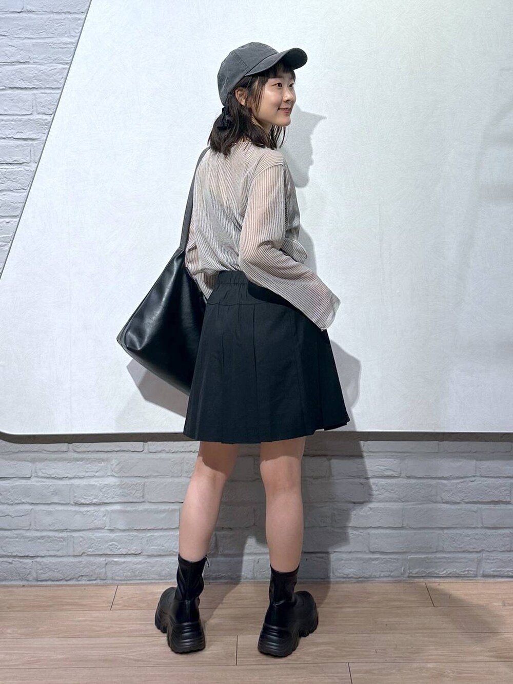 ブラック系のスカート、ブラック系のボディバッグ/ウエストポーチ、ホワイト系のシャツ/ブラウスを着用したレディースの夏コーディネートの3枚目の写真