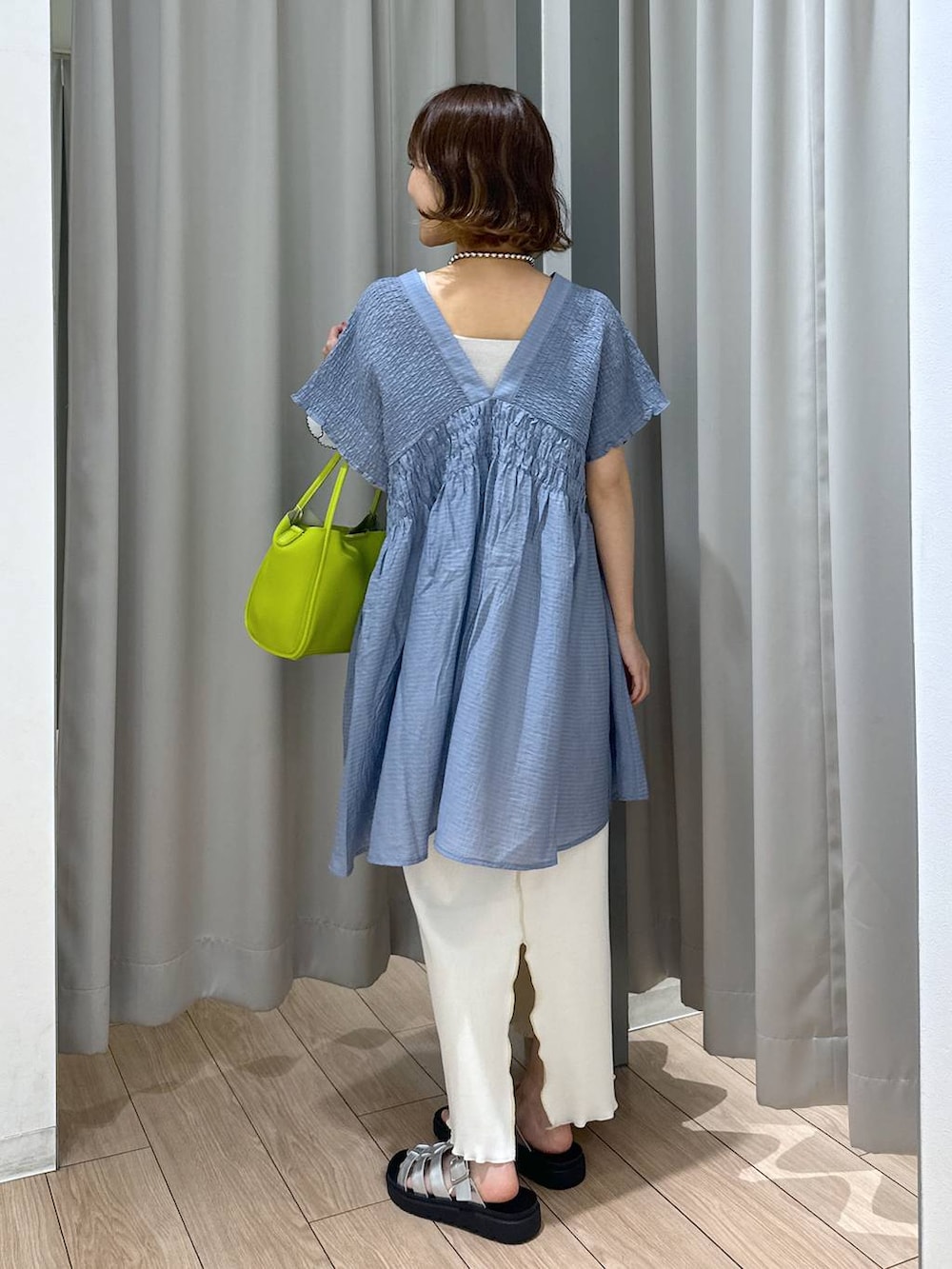 シルバー系のサンダル、シルバー系のタンクトップ、ホワイト系のスカートを着用したレディースの夏コーディネートの3枚目の写真