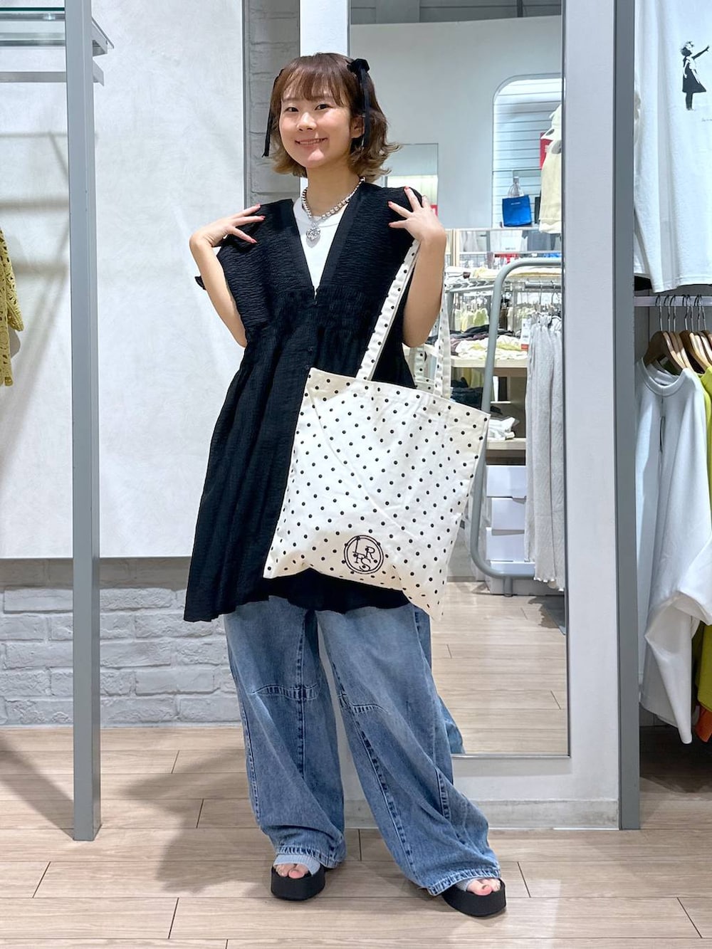 シルバー系のサンダル、その他のトートバッグ、ブルー系のデニムパンツを着用したレディースの夏コーディネートの4枚目の写真