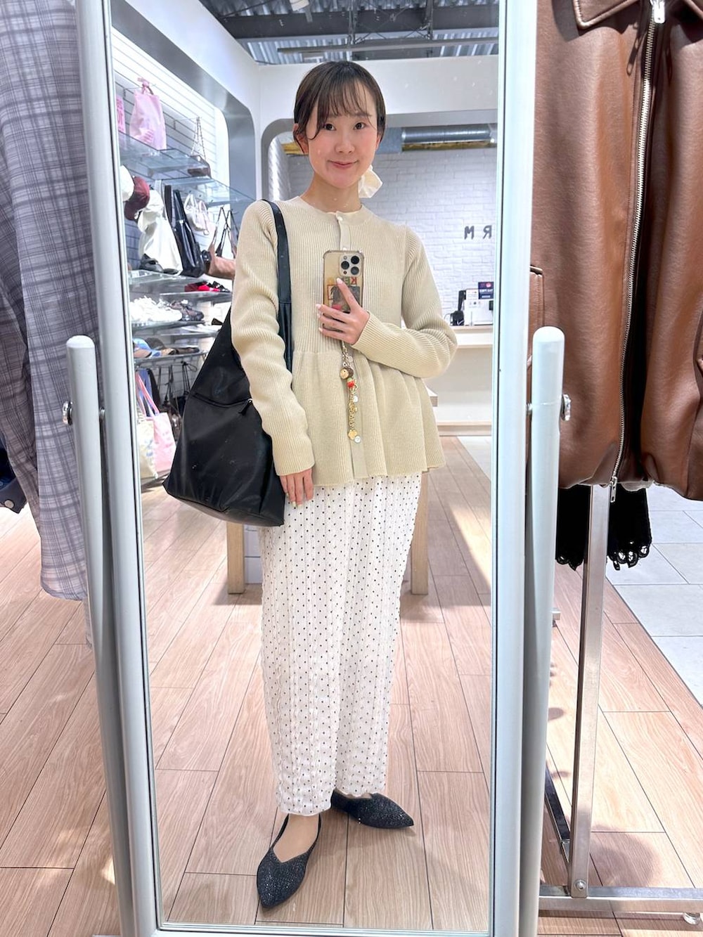 ブラック系のショルダーバッグ、ホワイト系のスカート、ホワイト系のカーディガン/ボレロを着用したレディースの春コーディネートの4枚目の写真