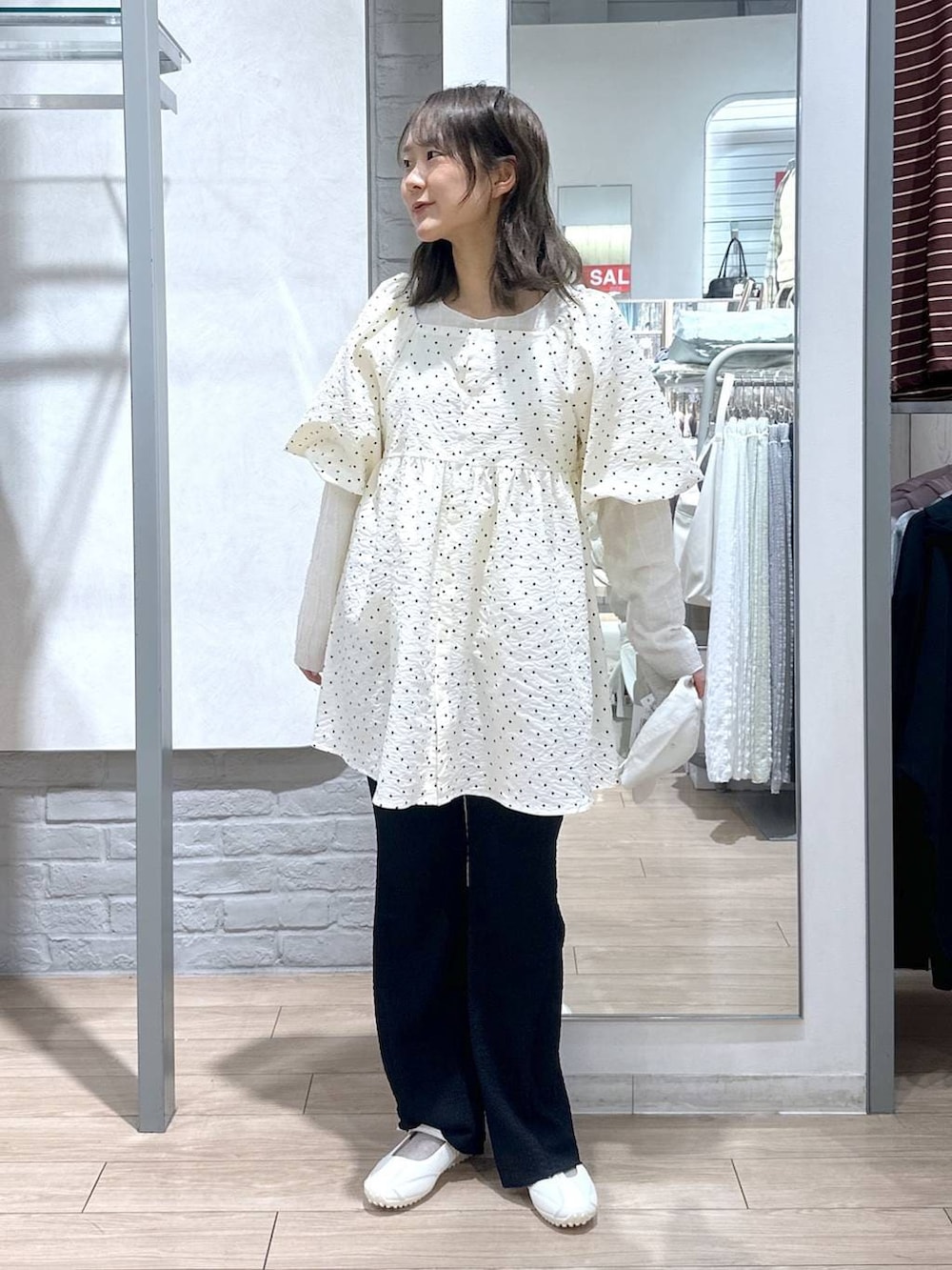 ベージュ系のTシャツ/カットソー、ホワイト系のスニーカー、ブラック系のその他パンツを着用したレディースの春コーディネートの2枚目の写真